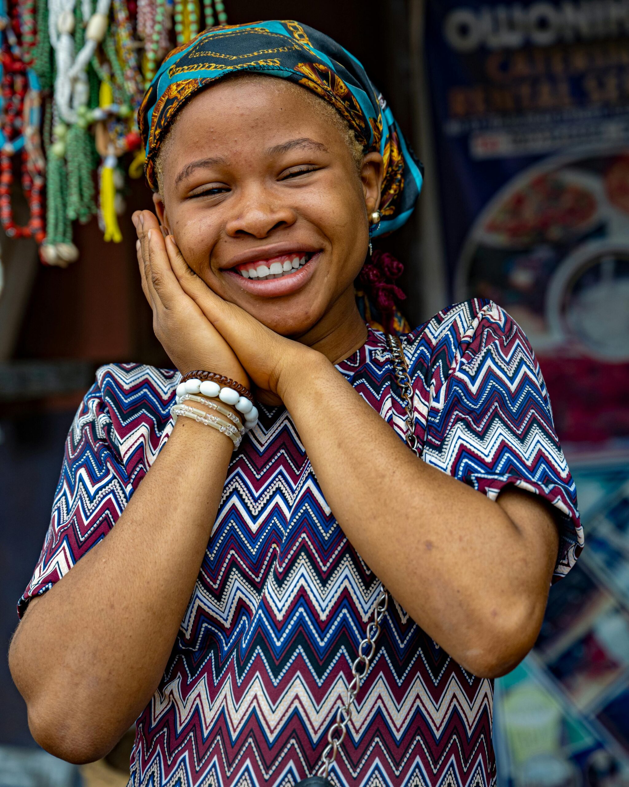 Portrait of a smiling woman in traditional Nigerian clothing, showcasing cultural beauty.